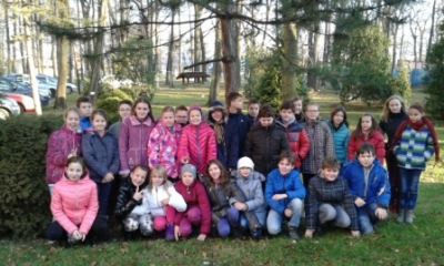 Prima krmí zpěvné ptactvo na školní zahradě.